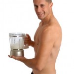 A man holding a blender containing a protein shake.