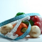 A selection of vegetables with a tape measure.