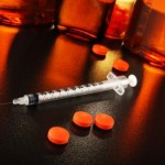 A syringe next to tablets.