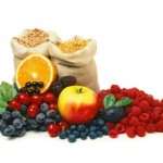 2 large sacks of cereal behind a selection of fruit.