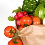 A selection of vegetables in a brown bag.