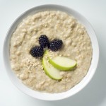 A bowl of porridge with apple and blackcurrant.