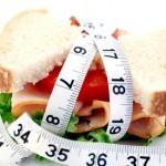 A sandwich wrapped in a tape measure.