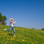 A woman running in a sunny meadow.