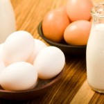 Eggs and milk on a wooden board.