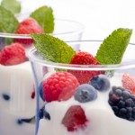 Two clear glasses of yogurt and fruit.