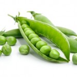 A close up of garden peas in a pod.