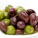 A selection of black and green olives on a white plate.