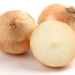Two whole onions and a chopped onion on a white background.