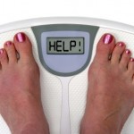 Two feet on a set of weighing scales with the message help.