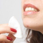 A woman wiping a spot on her chin.