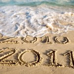A beach with 2010 and 2011 written on the sand.