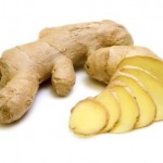 A whole and chopped ginger plant on a white background.
