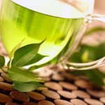 A clear, glass cup of green tea.