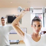 A man and a woman training in the gym.