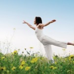 A woman practising yoga in a field.