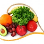 A selection of fruits and vegetables wrapped in a heart shaped tape measure.