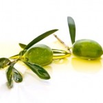 2 olives floating in a small pool of olive oil.