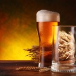 A pint of beer on a wooden table.
