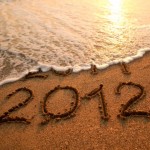 An area of sand near the sea containing the writing 2012.