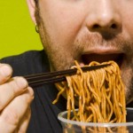 A man eating lots of noodles.