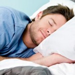A man smiling and sleeping.
