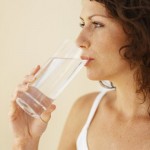 A woman drinking a glass of water.