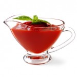 A glass jug containing tomato ketchup.
