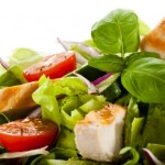 A close up shot of a tomato and chicken salad.