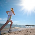 A woman running on a sunny beach.