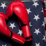 An American flag next to a pair of boxing gloves.