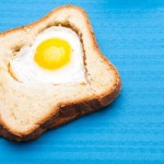 A heart shaped egg within a slice of toast.