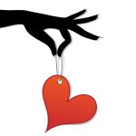 A black hand holding a red, heart shaped Valentine's Day gift tag.