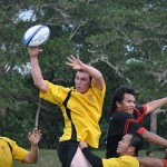 A man catching a rugby ball during a game.