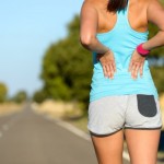 A woman holding her lower back.