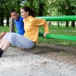 A couple performing dips outside.