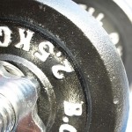 A close up shot of a dark grey dumbbell.