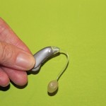 A hearing aid on a green background.